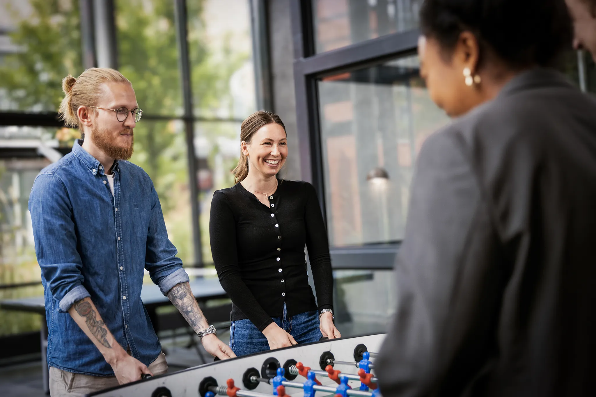 Diverse group of Agillic employees playing table football.